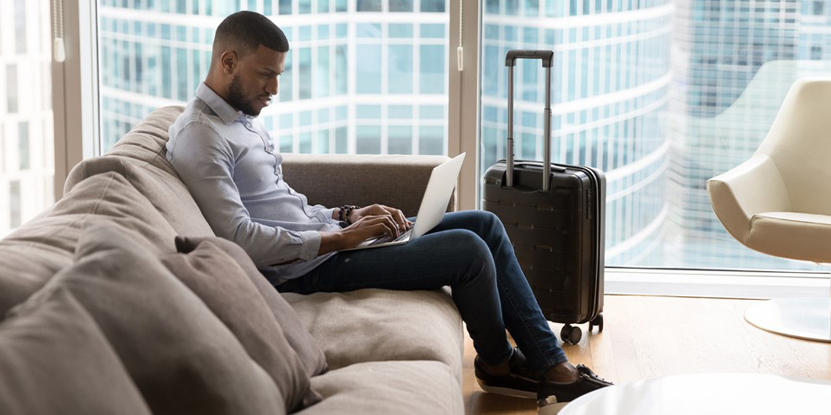 A man using a laptop in his hotel room.